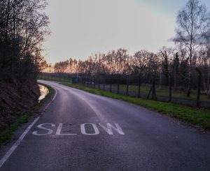 Road with a 'slow' marking at sunset