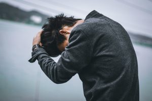 man in black long sleeve shirt covering his face