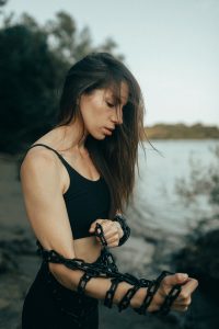 Woman with chains wrapped around arms outdoors