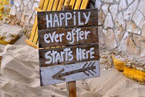 Wooden sign reads 'happily ever after starts here'.