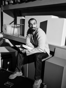 Man sitting on a shelf holding a book.