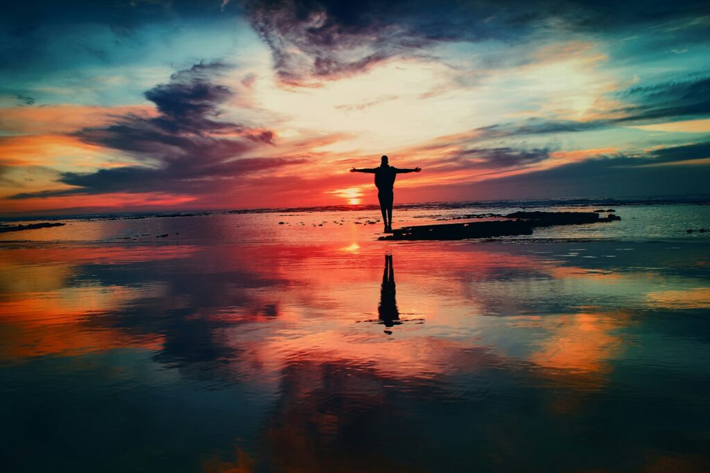 Purpose - silhouette of person standing on rock surrounded by body of water - Tamara Lea Patrick