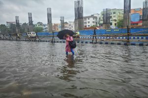 A person walking through a flooded street with an umbrella