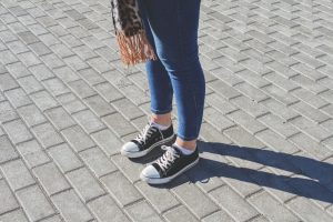 a person standing on a brick walkway with a handbag